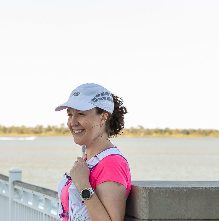 Woman runner leaning against bridge