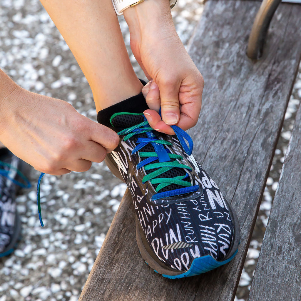 Running shoe with hands tying laces