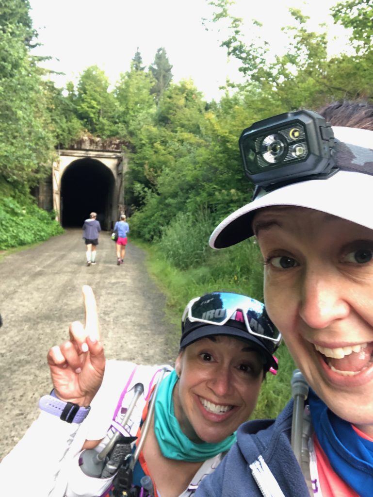 Runners smiling in front of a tunnel