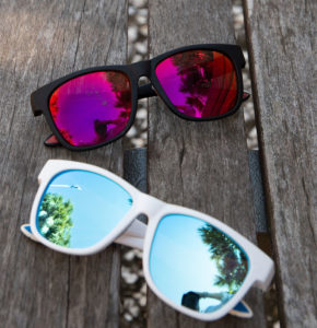 two pairs of sunglasses on bench